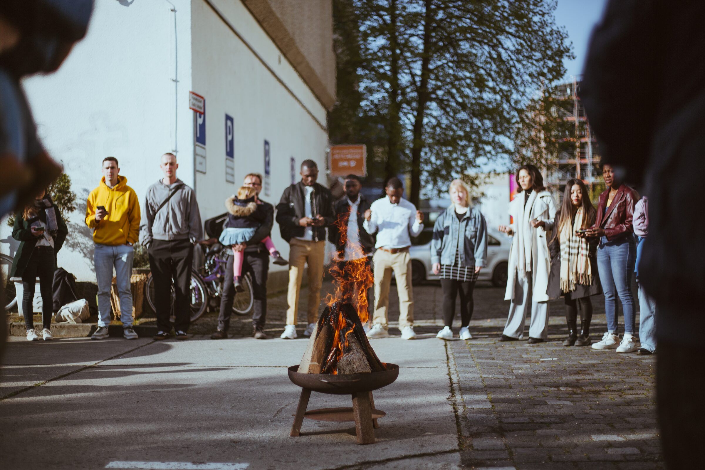 Menschen stehen im Hof um eine Feuerschale
