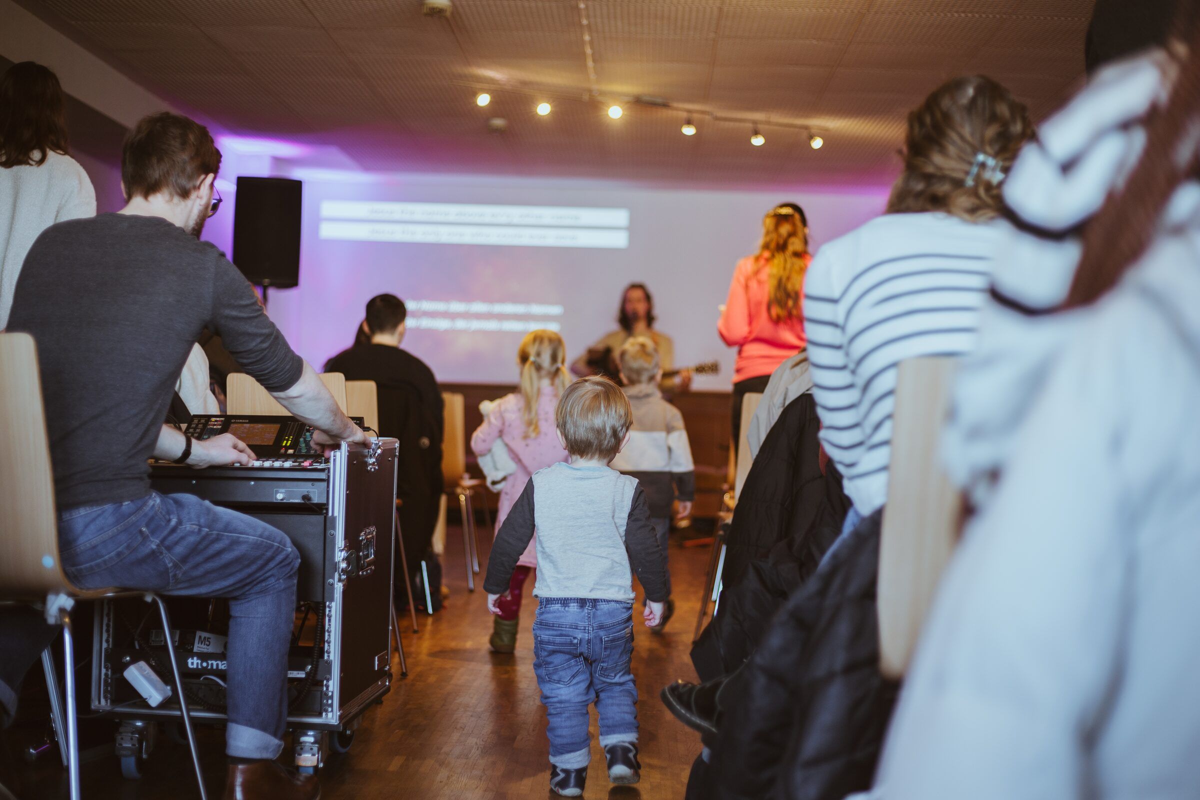 Kinder tanzen im Gottesdienst, hinten das Technikpult