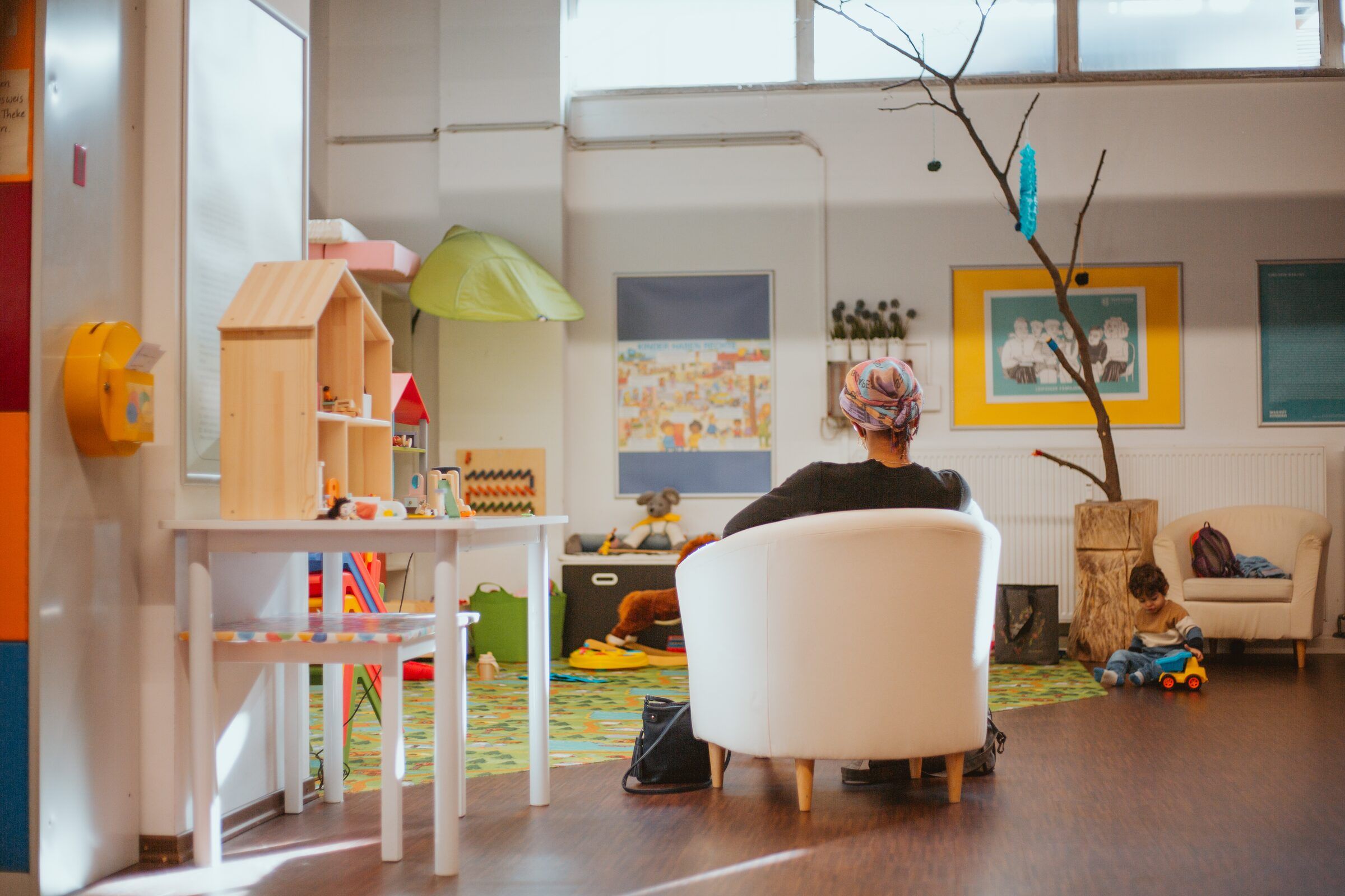 Heller Kinderraum mit Puppenhaus, Spielecke und Sessel