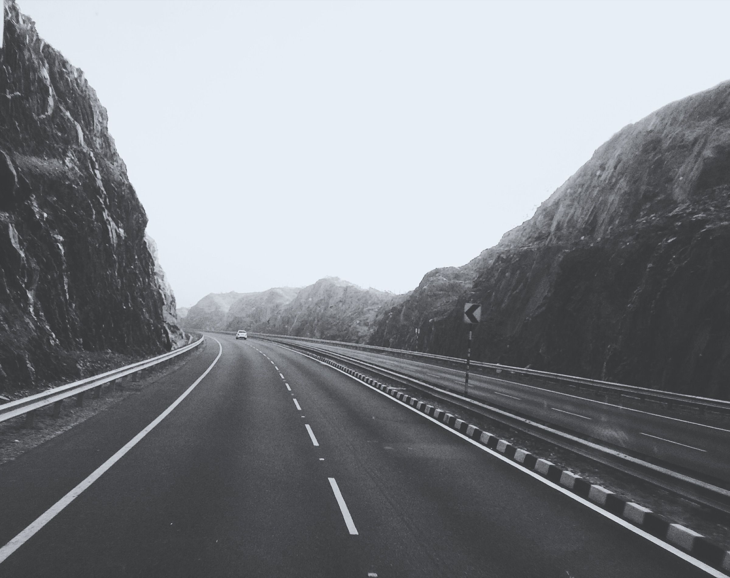An empty road leading between steep rock faces