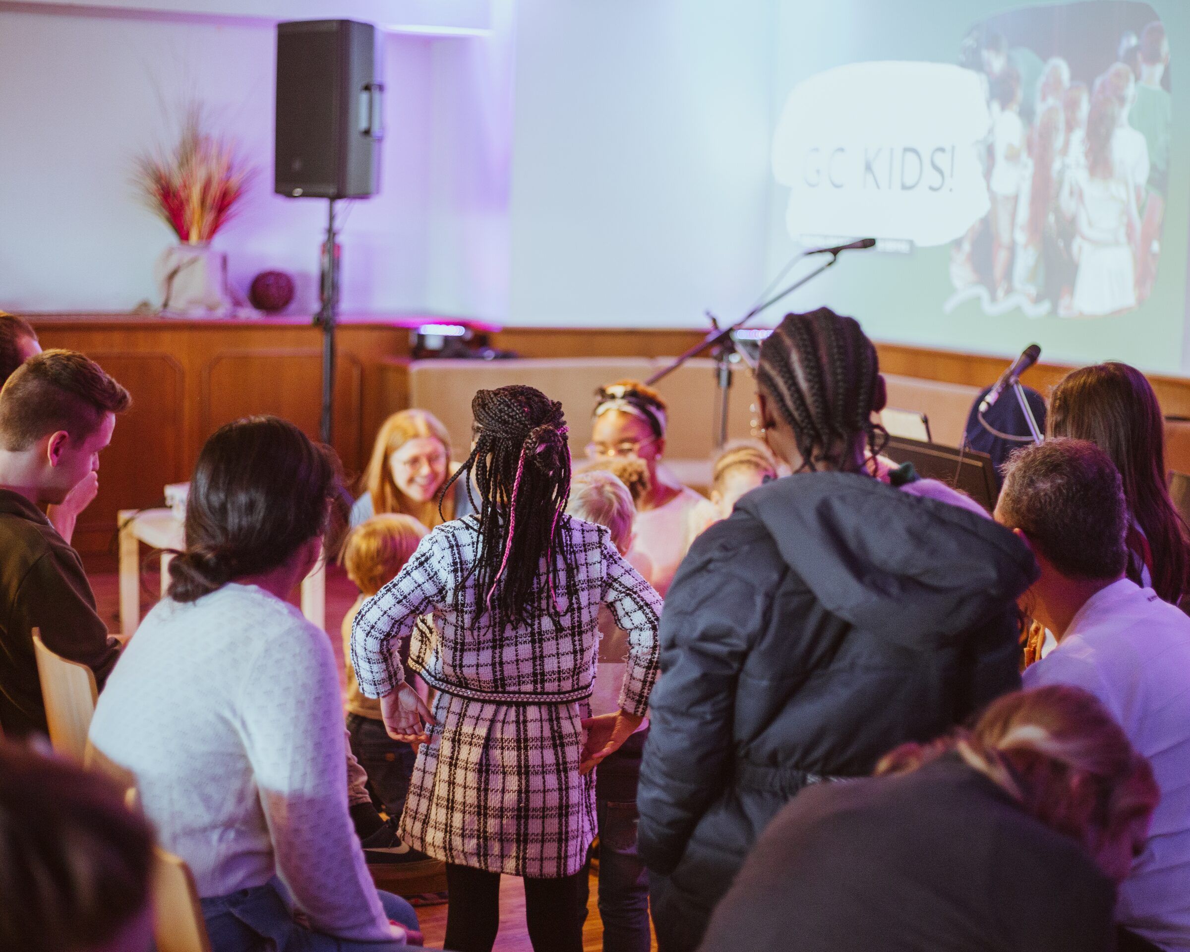 Kinder und Erwachsene versammeln sich vorne im Gottesdienst
